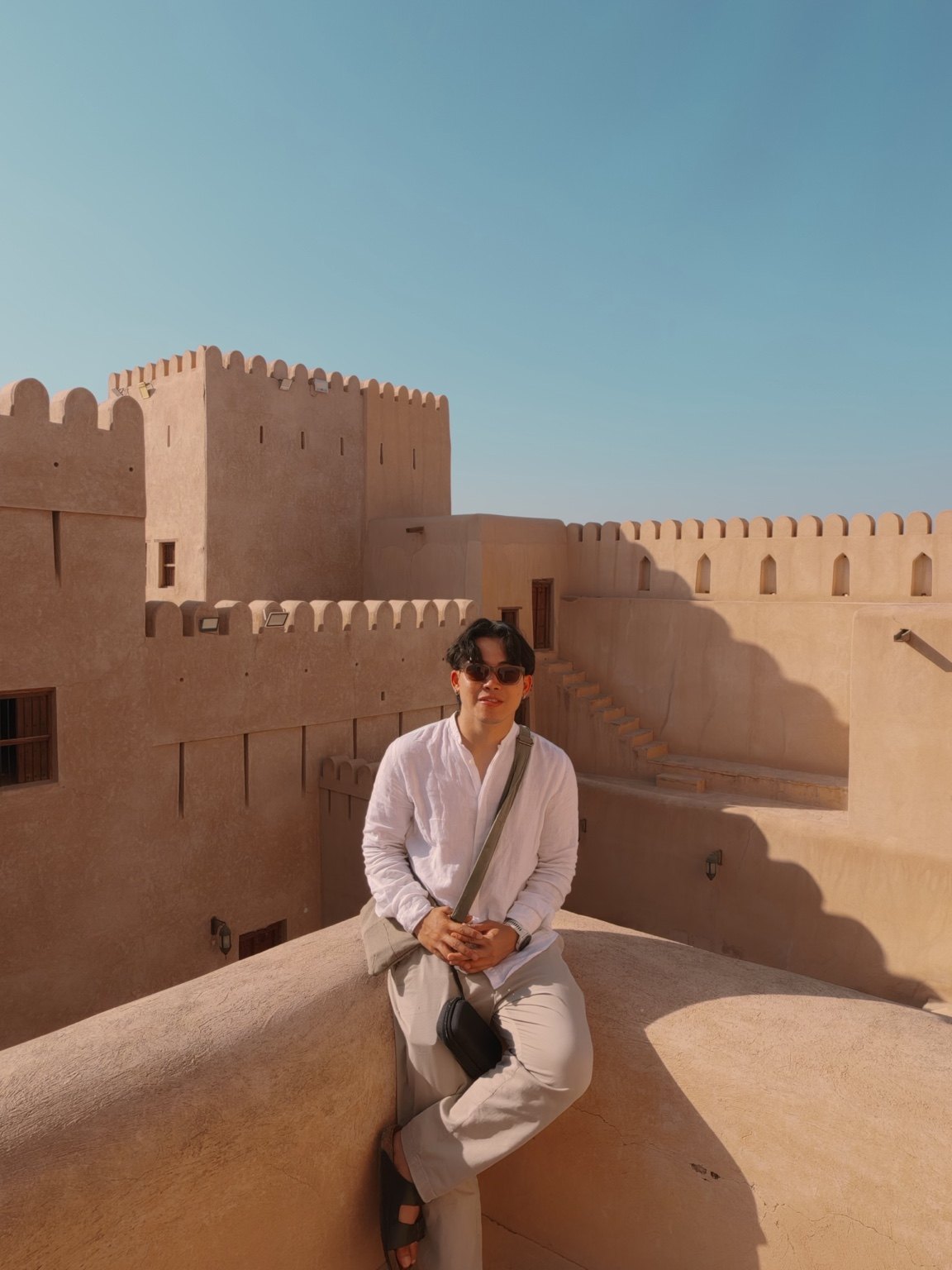 Dan seated outdoors against sunlit fort walls